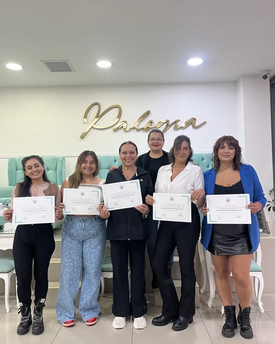 Cinco alumnas con sus certificados y la profesora detrás, frente al logo dorado de Paloma.
