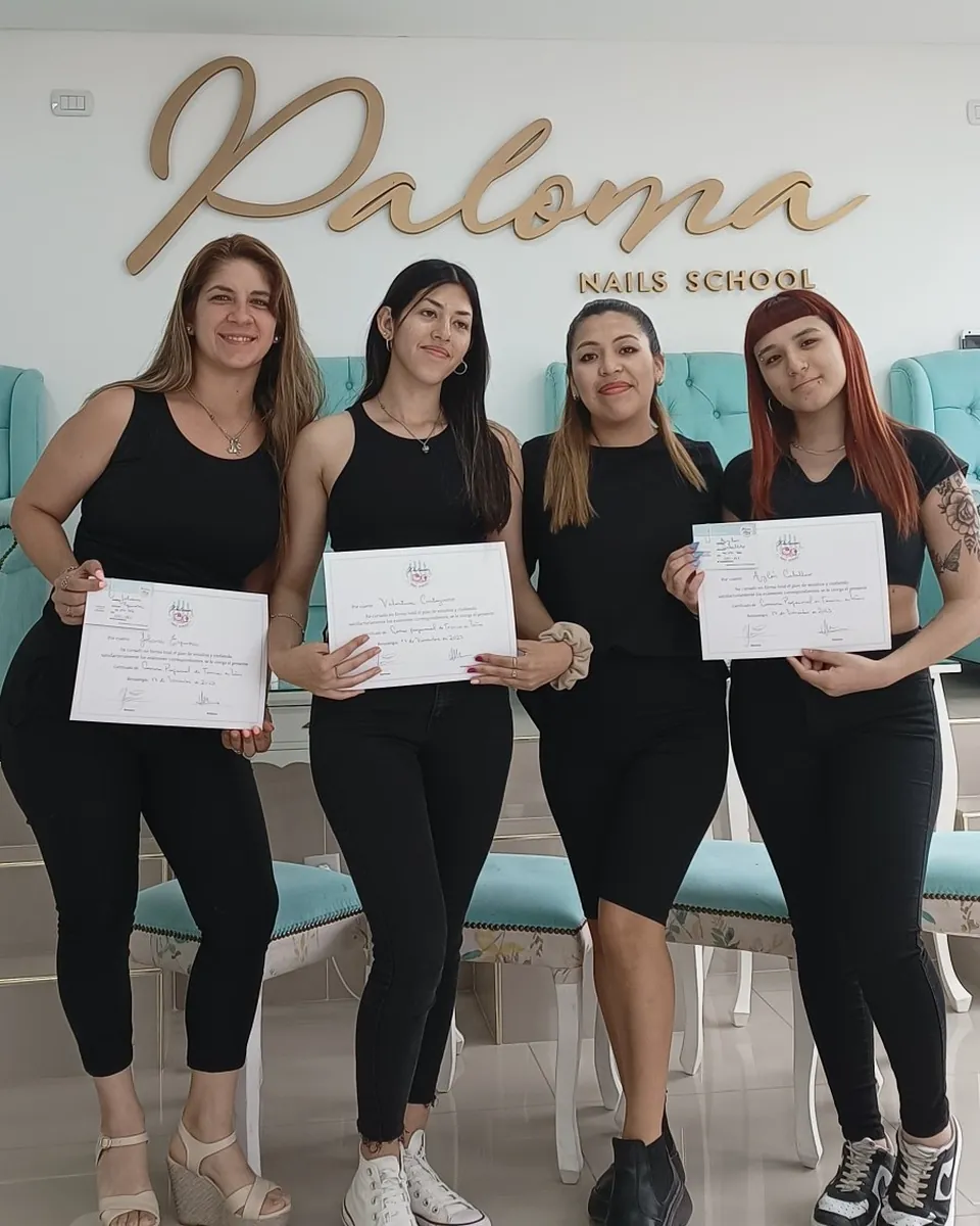 Tres alumnas de la Carrera Profesional de Técnica en Uñas con sus certificados junto a la profesora, bajo el logo de Paloma Nails School.