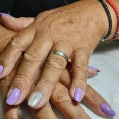 Manos con esmaltado semipermanente lila y una uña en verde agua, hecho por Gri Godoy.